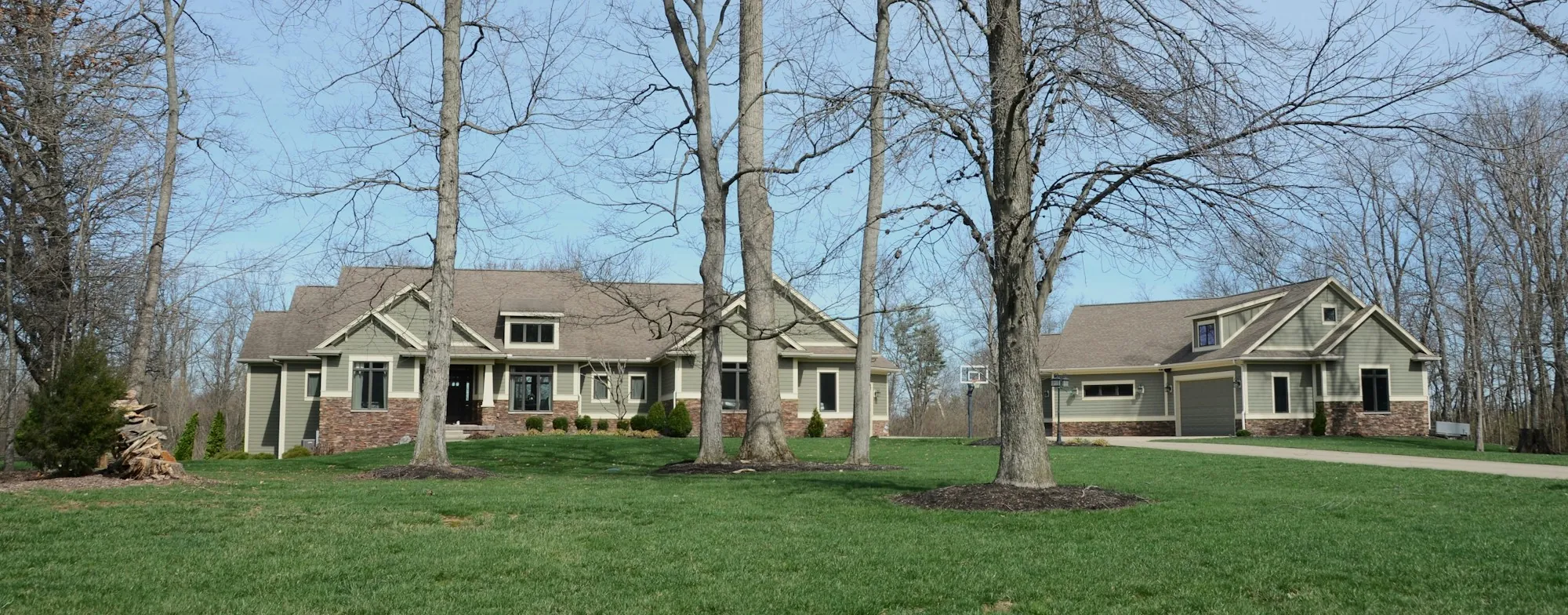 Suburban homes set back on wide lawns along a tree-lined street