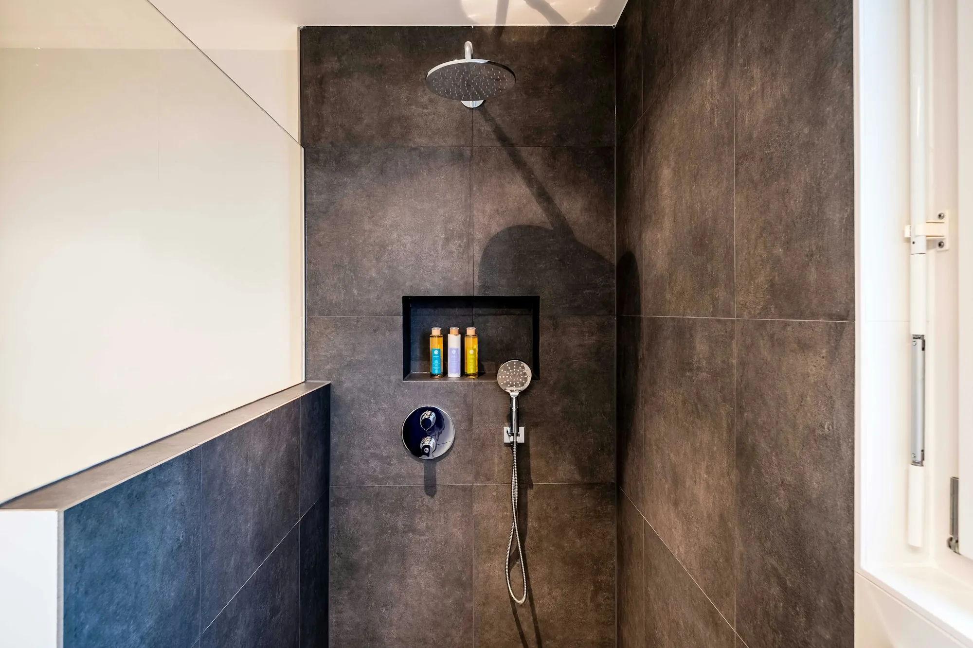 Remodeled bathroom with a glass walk-in shower and a floating vanity