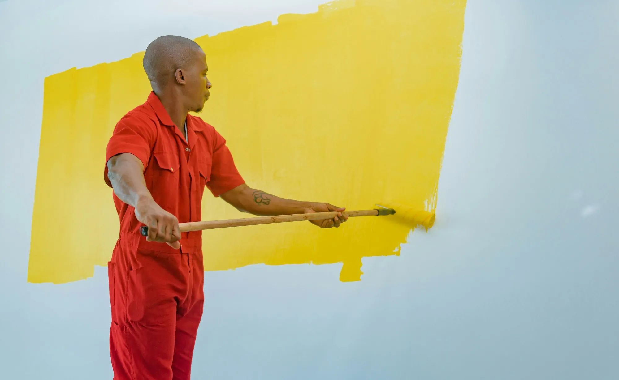 Painter cutting in along a ceiling line with a brush